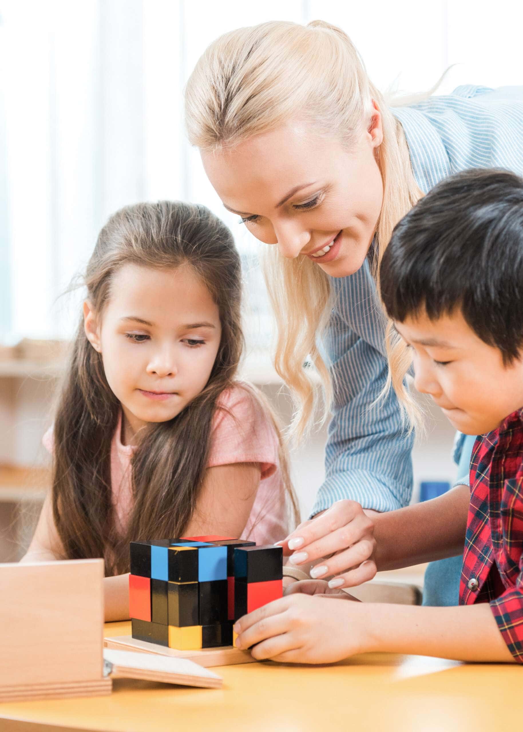 Montessori education: A Primary teacher giving a lesson with the Montessori Trinomial Cube in a Kindergarten classroom