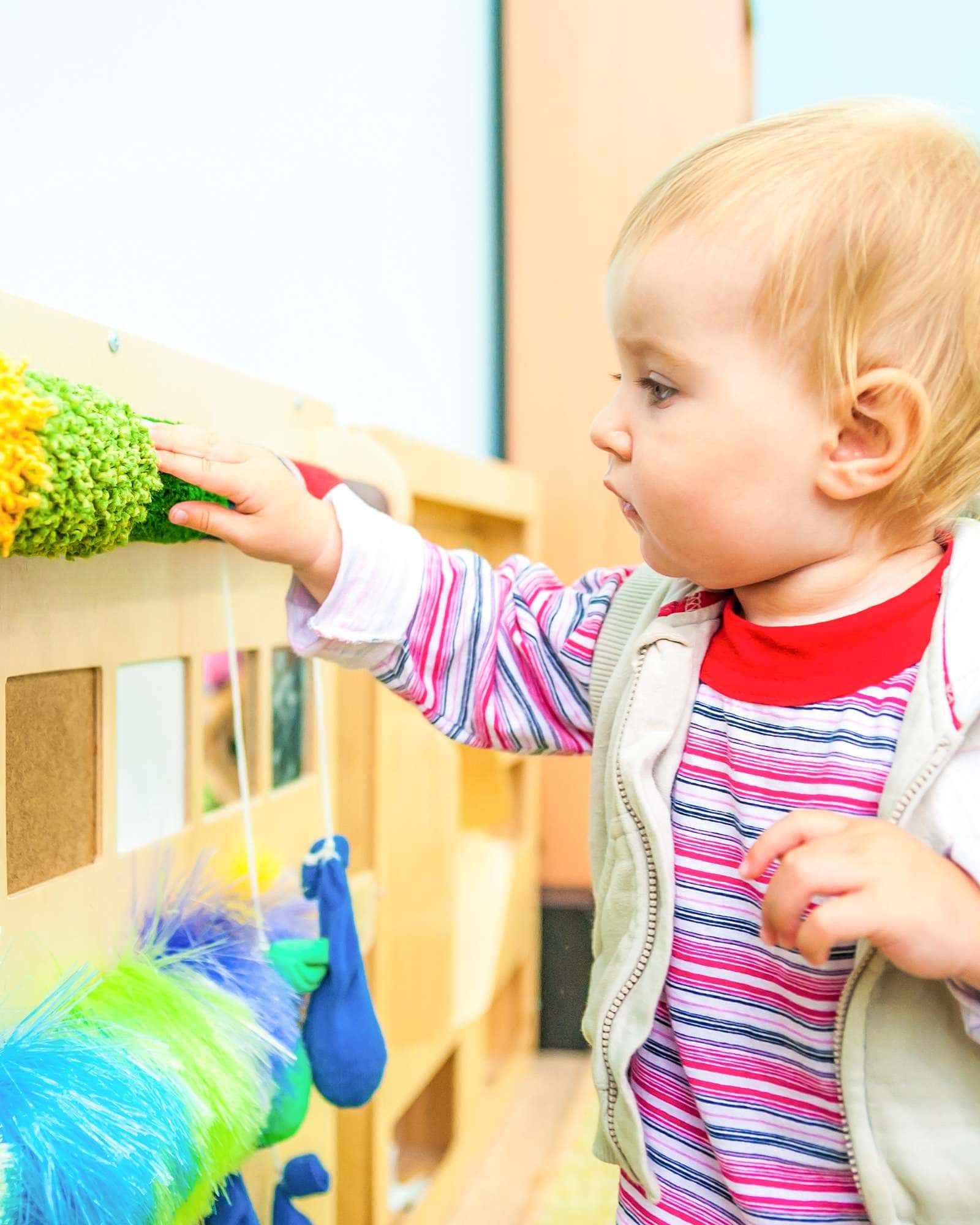 An infant exploring in her Early Childhood Education Infant classroom