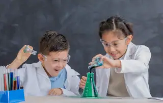 Early Learning for a Changing World. Two children in a science classroom with lab equipment.