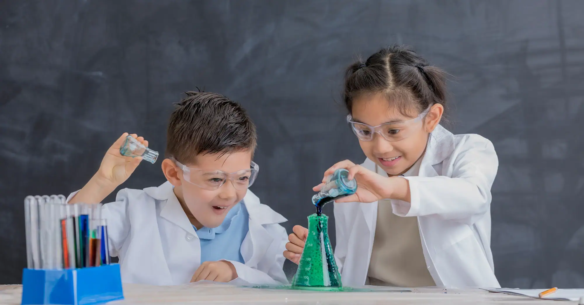 Early Learning for a Changing World. Two children in a science classroom with lab equipment.